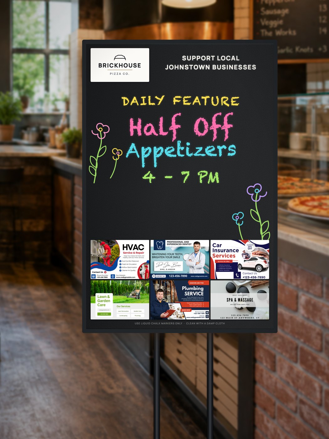 A Community Board on its stand inside a pizzeria, showing the host logo, one large handwritten daily feature and six business placements