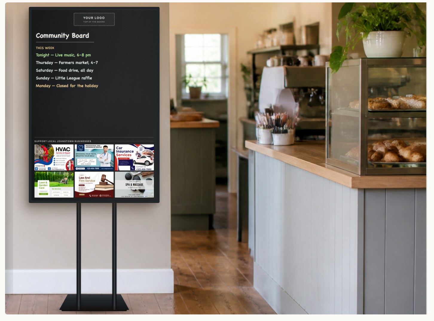 A Community Board on its stand inside a bakery, showing the host logo, the writable panel and six sponsor spaces